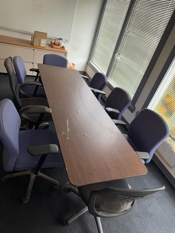 Foldable table with eight rolling office chairs