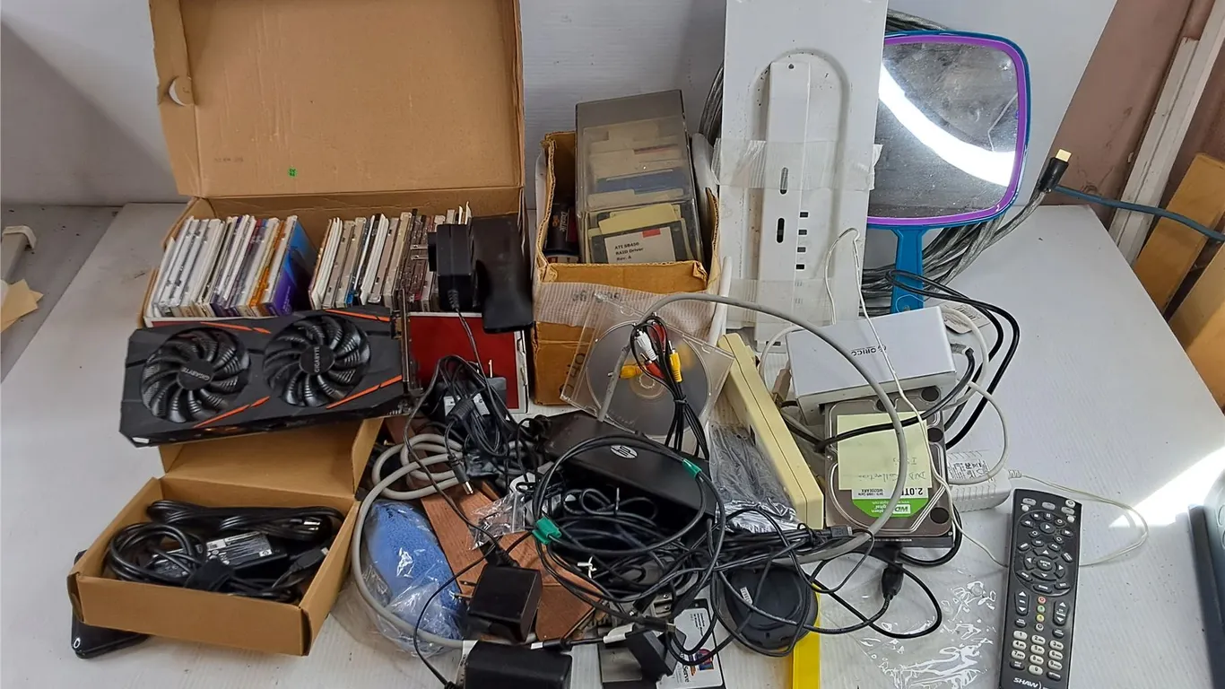 Assorted CDs, Floppy Discs, MakeUp Mirror, Power Bar, Gigabyte Video Card, Remote, Misc