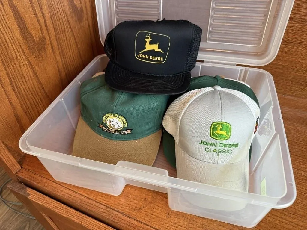 Storage tote of John Deere, assorted ball caps