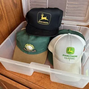 Storage tote of John Deere, assorted ball caps