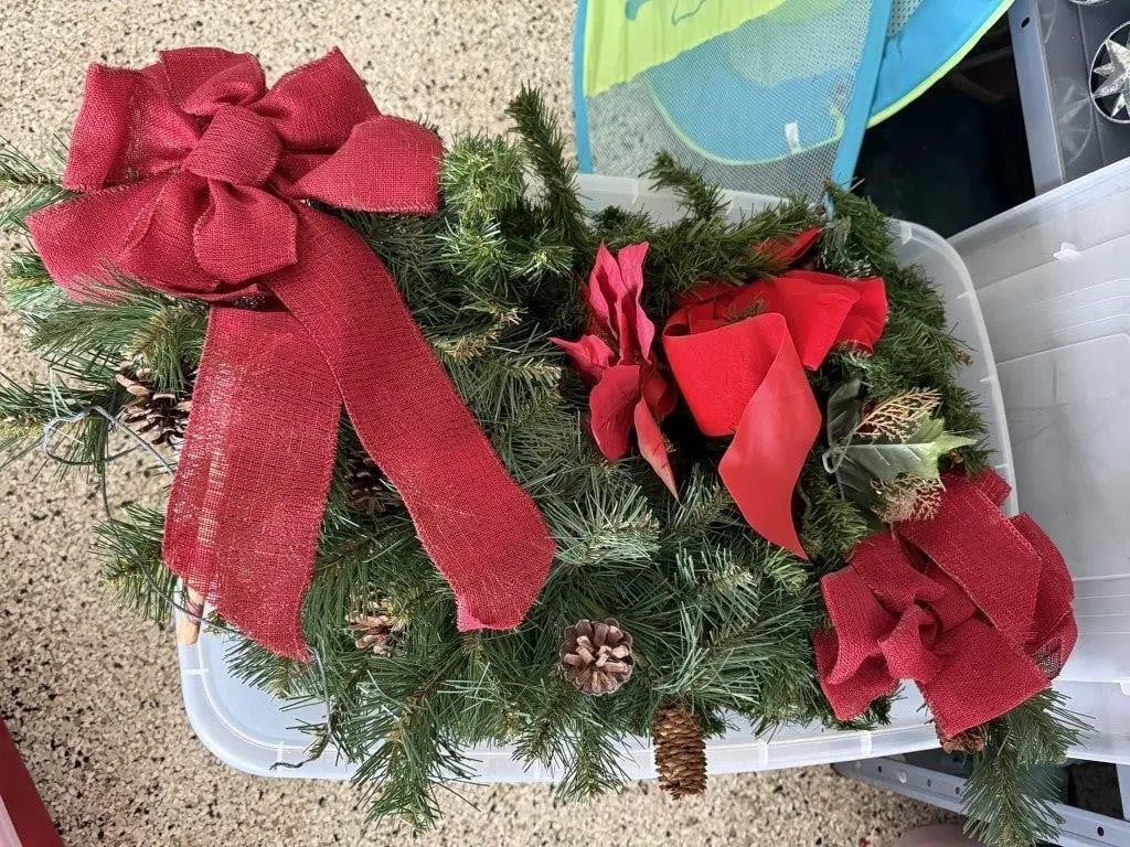 Storage tote of holiday greenery, swags