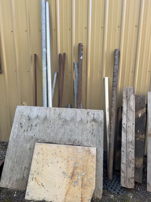 Scrap Lumber, Metal Poles, and Two 55-Gallon Plastic Barrels