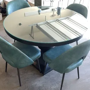 Round Glass Top Dining Table With Black Pedestal Base And Four Teal Upholstered Chairs