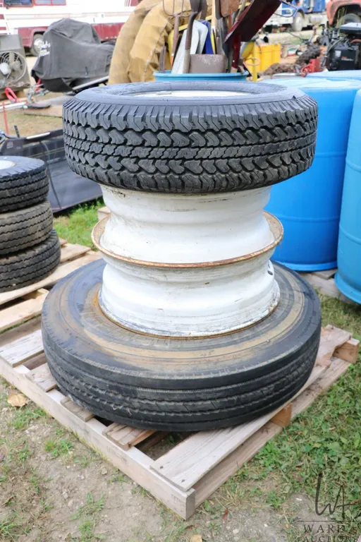 Two 22.5" rims, one Michelin 10R 22.5 XZE tire and GM marked alloy 8 bolt rim fitted with Michelin L