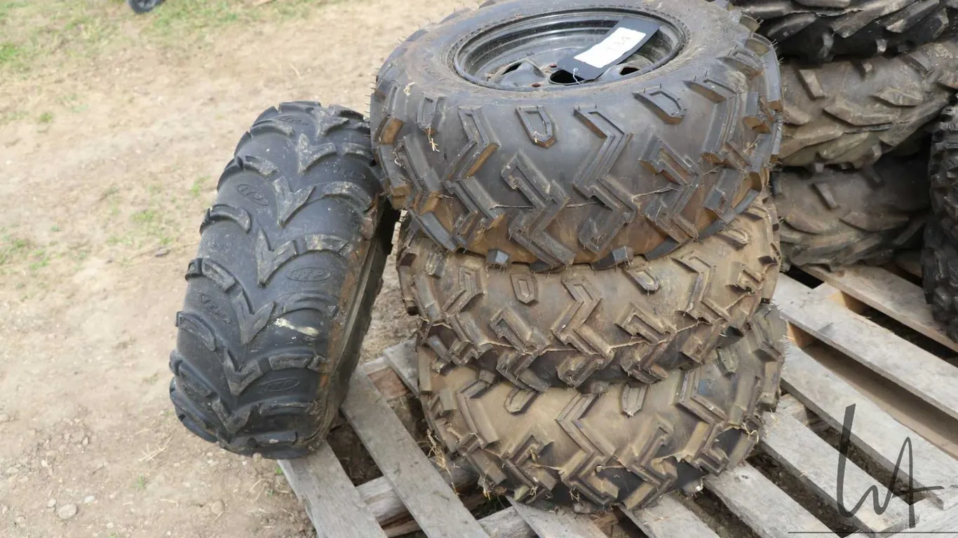 Four ATV tires on rims. Three are matching. See photos for makes and sizes