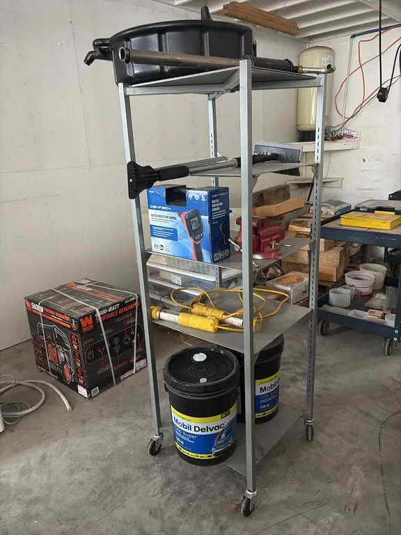 Portable shelf w/ unused Cen-Tech digital inspection camera, barrel pump, small Craftsman vise & 2) 5 gallon pails of Mobil 15w-40 oil