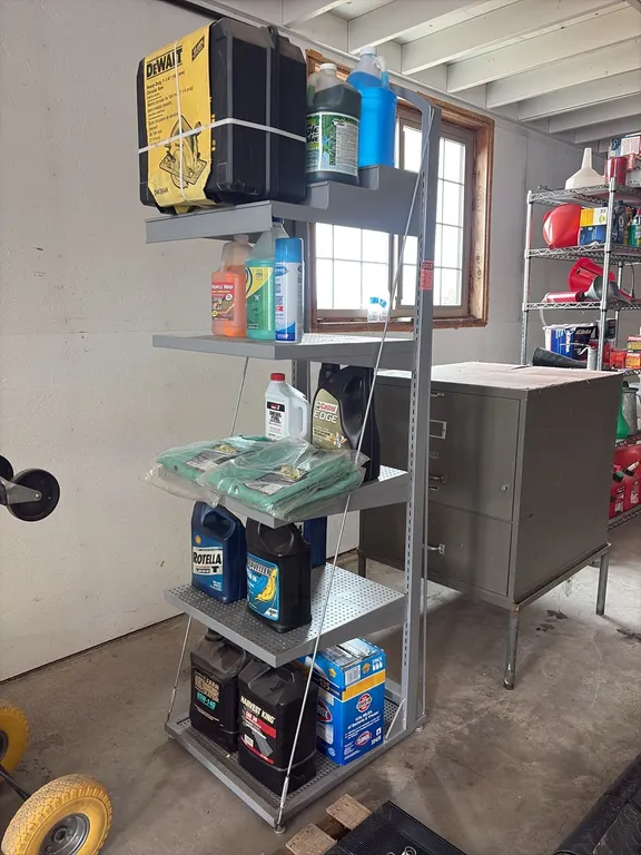 Shelf w/ unused DeWalt 7.25" circular saw, welding jackets & assorted oil