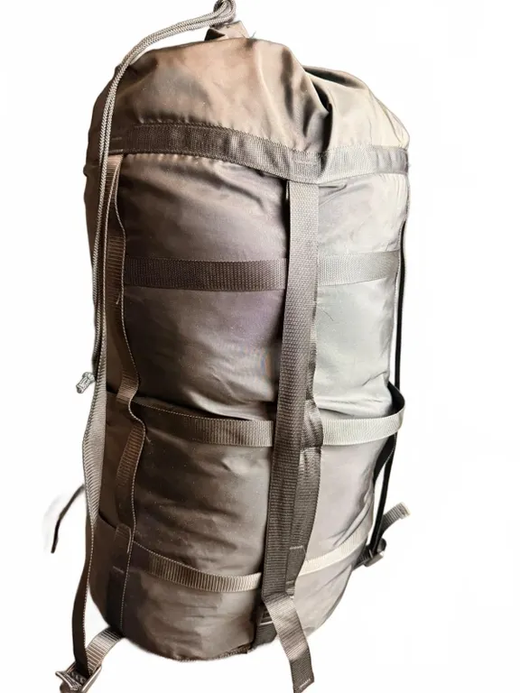 Black Compression Sack with Yellow Sleeping Bag Inside