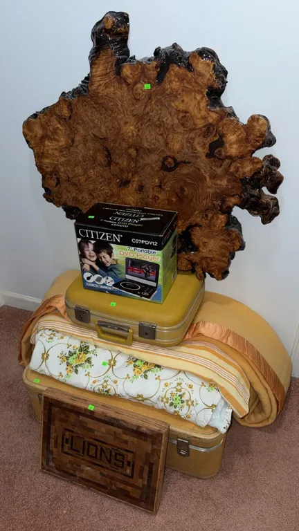 Lot with Citizen 7" Portable DVD Player, Yellow Suitcases, Burl Wood Slab, Lions Plaque, and Linens