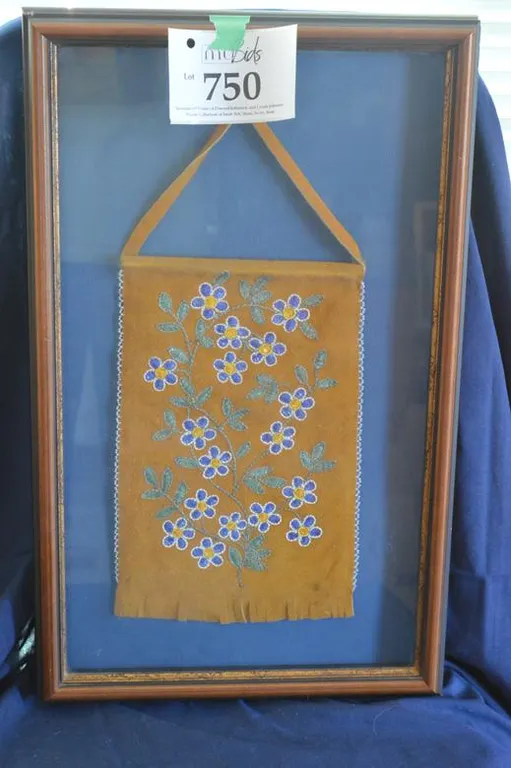 A Framed Moose Hide Hanging With A Northern Flower