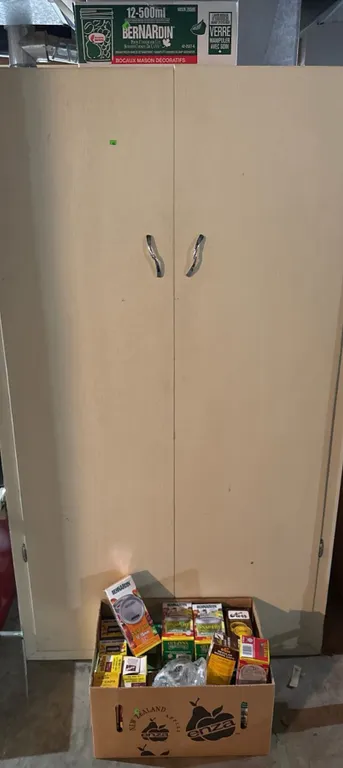 Tall Wooden Storage Cabinet With Mixed Canning Supplies and Glass Jars