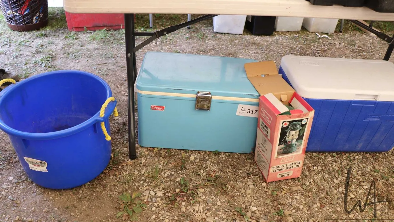 Two coolers, one vintage, one newer, a Coleman lantern and a blue tub