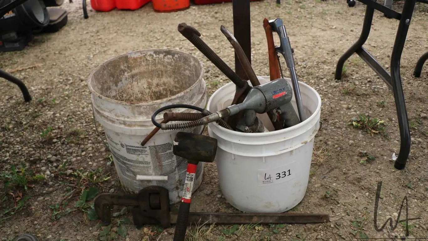 Selection of miscellaneous tools including grease gun, pipe wrench, rubber hammer, hack saw etc.