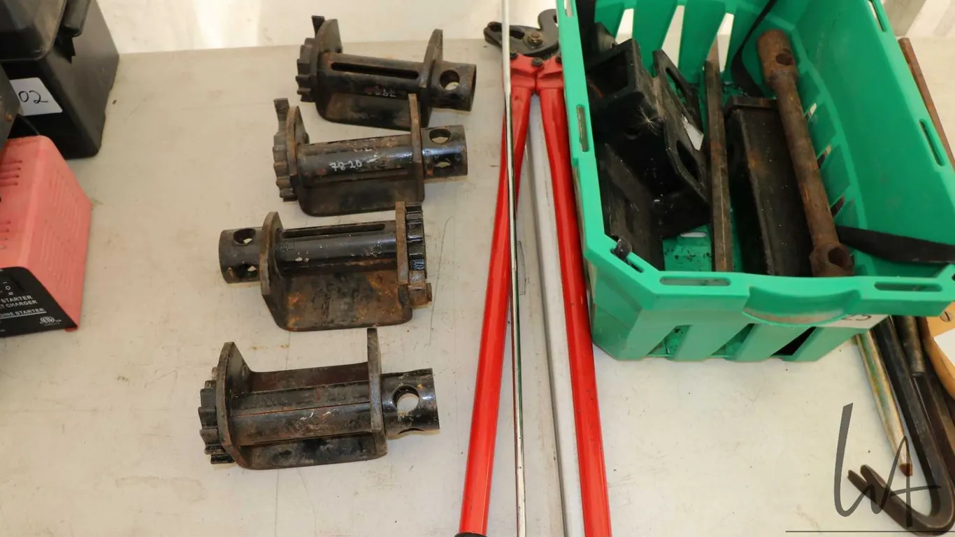 Four strap ratchets, trailer hitch components, kingpin hook, tire chains, pliers etc.