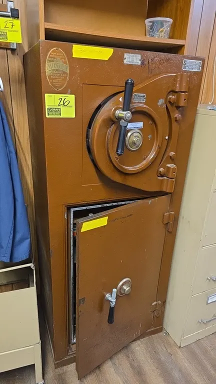 Mosler 2-door combination safe. Features upper round door with combination lock and interior deposit compartment with drop slot, and lower door with c