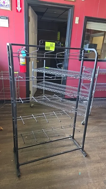 Metal 5-tier display merchandiser rack. Features black metal construction with 5 tiers of hanging wire display hooks and a freestanding base. 33" x 10