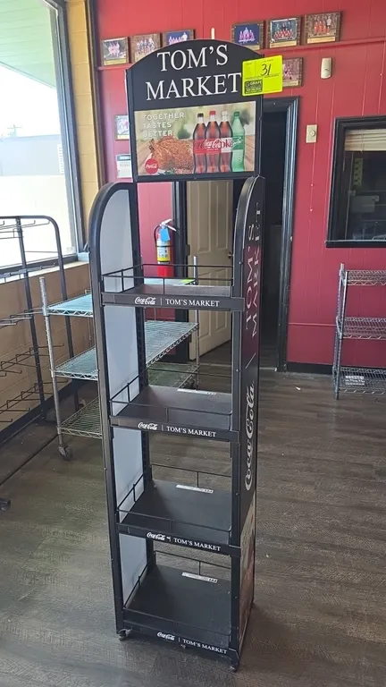 Metal 4-tier merchandiser display rack. Features 4 adjustable shelves with wire retainers, Coca-Cola and Tom's Market branding, and top promotional si