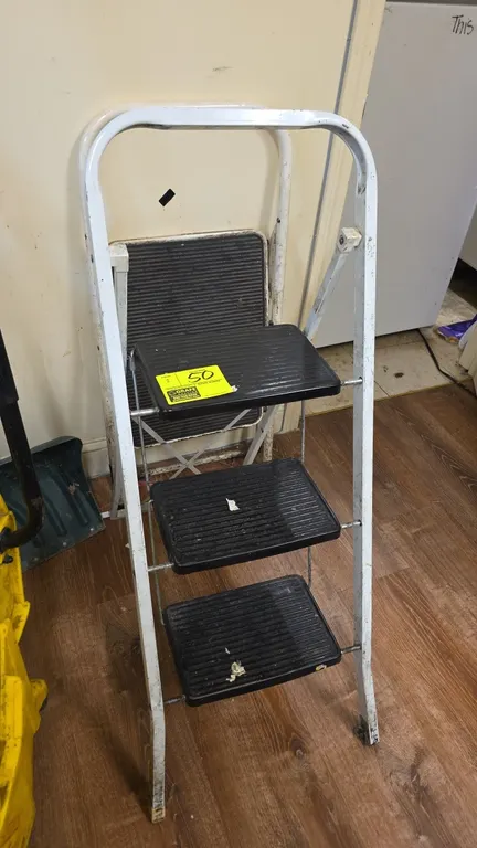 Metal folding step ladders. Includes (1) 2-step ladder and (1) 3-step ladder. Features white tubular metal frames, folding mechanisms, upper hand grip