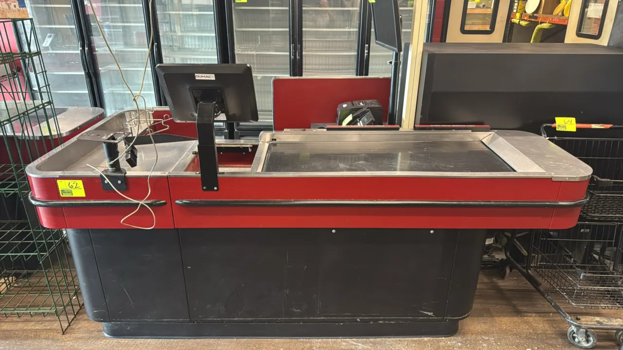 Lyons Store Fixtures R446 metal single belt check lane. Features motorized conveyor belt, stainless steel top and trim, wire grocery bag stand, and ca