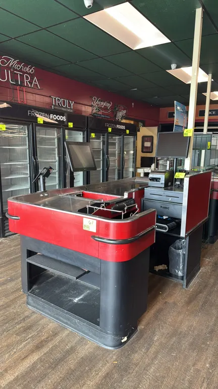 2014 Lyons Store Fixtures R446 motorized single belt checkout lane. Features stainless steel deck, wire bag rack, scanner well, cashier stand, and low