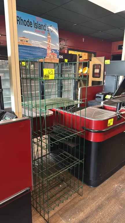 Metal 5-tier merchandiser display rack. Features green wire construction, 5 shelving tiers, and top graphic header sign. 21" x 17" x 61".