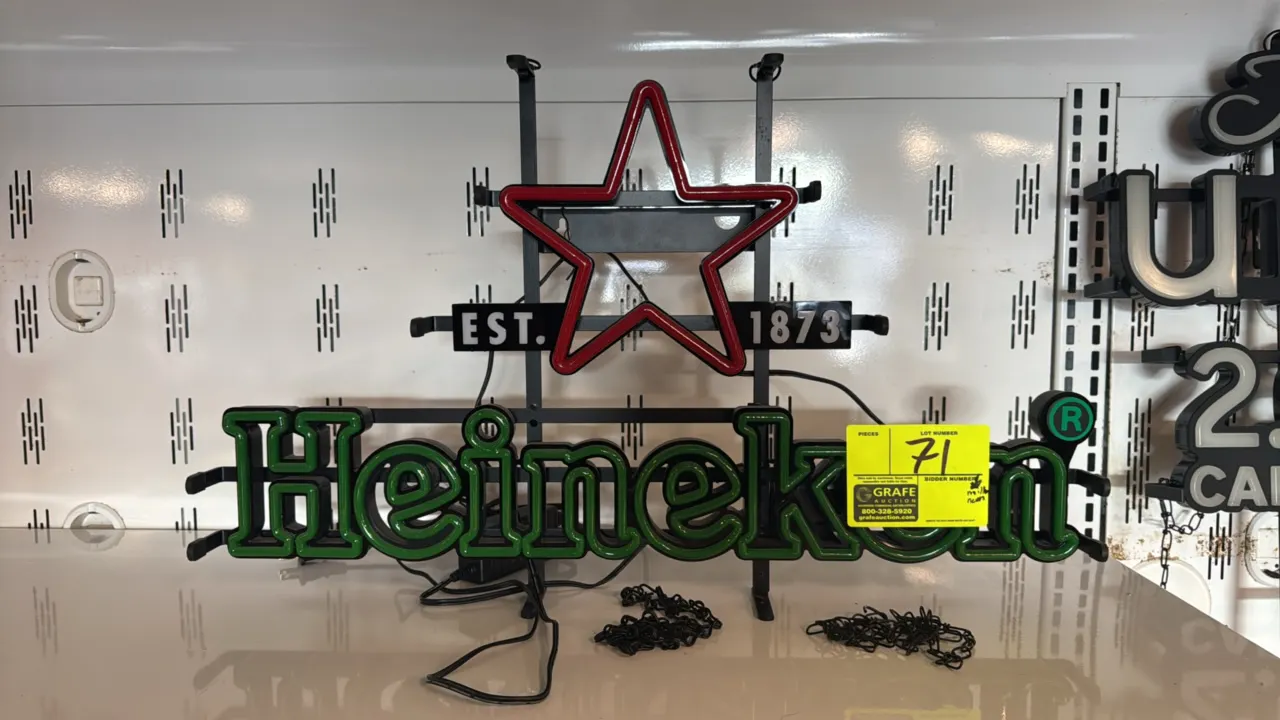 Heineken neon sign. Features red star emblem, 'EST. 1873' text, and green Heineken lettering mounted on a black metal frame. Includes hanging chains a