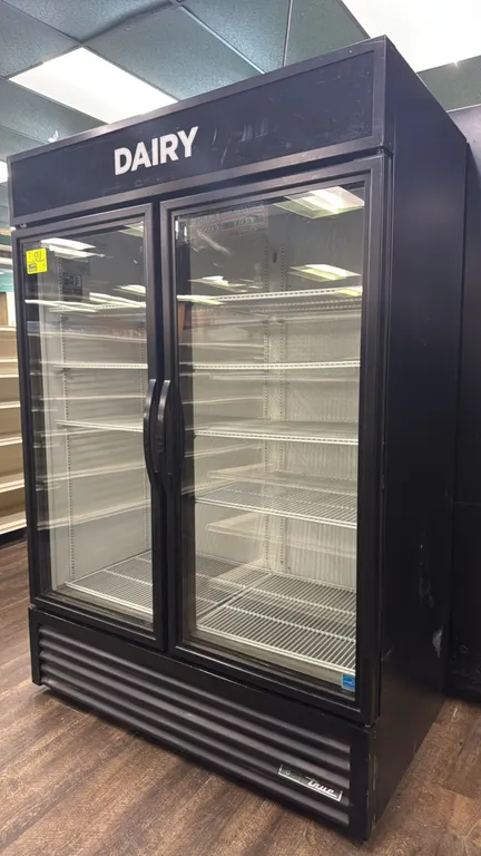 True GDM-49-HC~TSL01 glass 2-door merchandiser refrigerator. Features illuminated "DAIRY" sign panel, 2 hinged glass doors, interior LED lighting, and