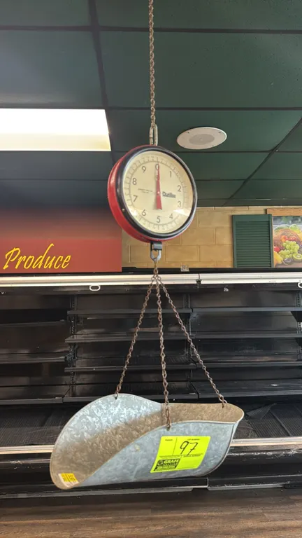 Chatillon Type 720 hanging produce scale. Features a 20 lb x 1 oz capacity analog dial, red metal casing, and a galvanized metal scoop pan suspended b