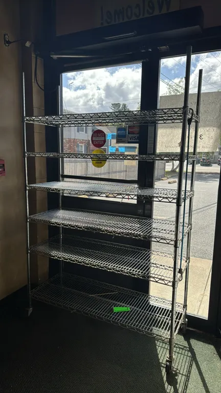 Chrome 6-tier wire shelving rack. Features 6 adjustable wire shelves. 48"W x 18"D x 76"H. Mounted on swivel casters.