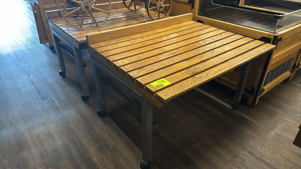 Portable tilting produce display tables. Features slatted wood tops with rear retaining lip and metal frames with adjustable tilt positioning. 4'L. Mo