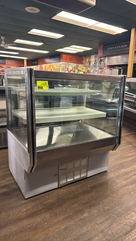2005 Refrigeration Manufacturing Inc. slant glass self-contained deli display case. Features stainless steel trim, slanted front glass, rear sliding g