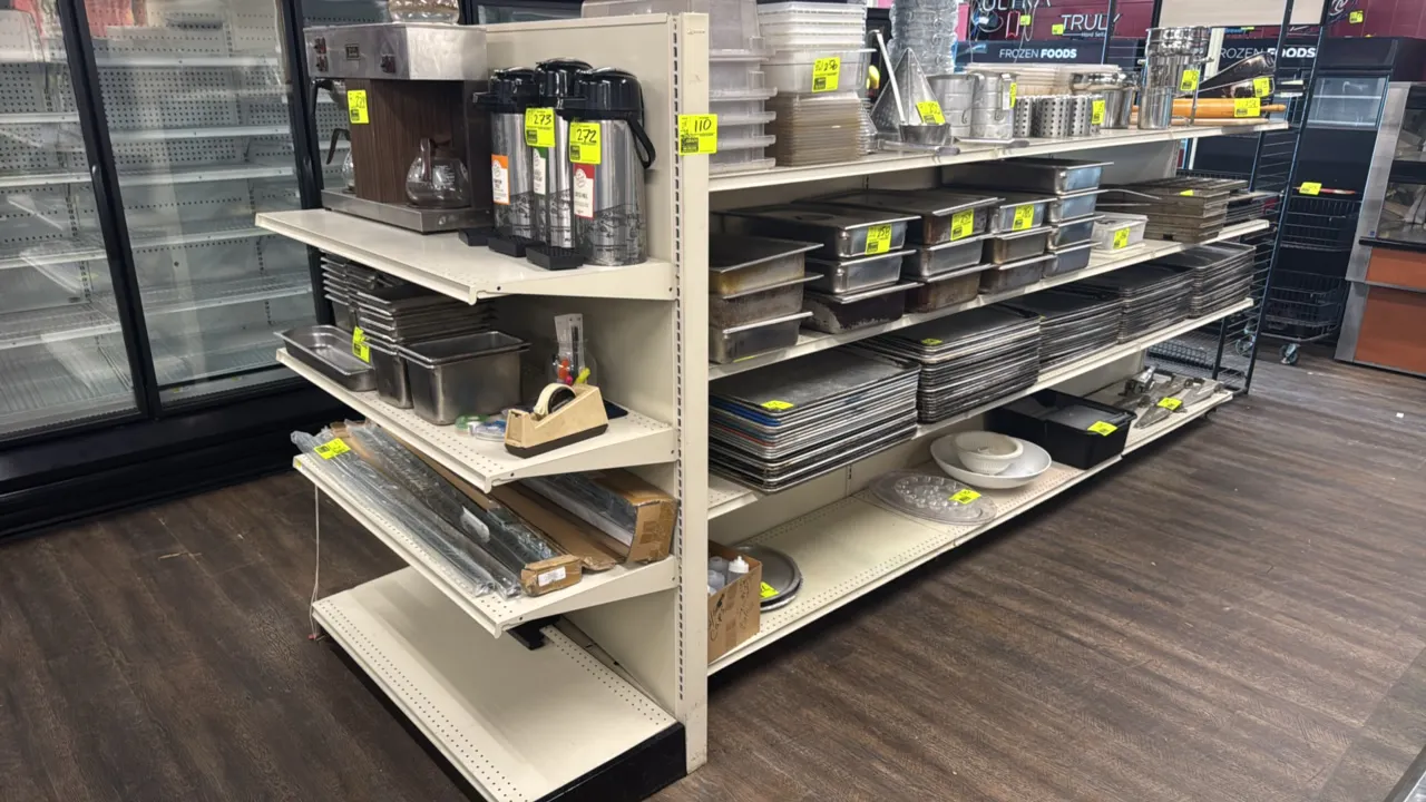 28'L of Lozier gondola store shelving. Features 60"H uprights with 19"/19" base shelves, adjustable upper shelves, and a 72"H end cap. Contents not in