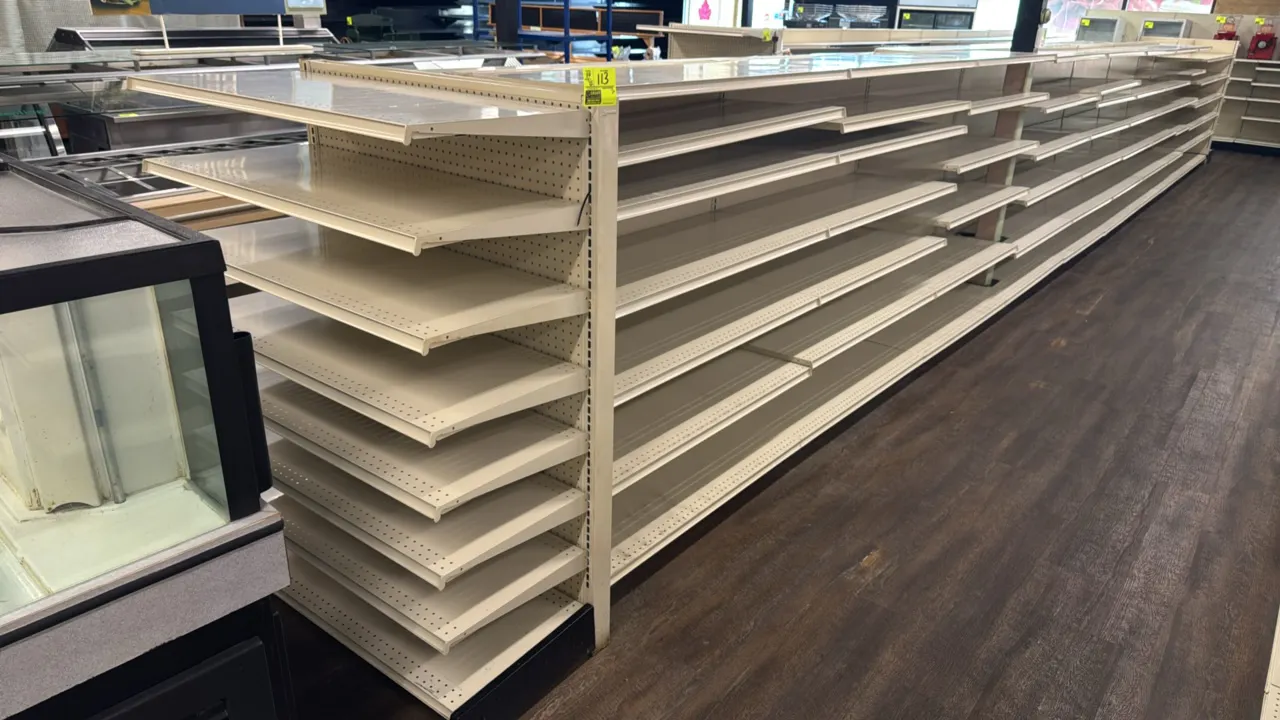 86'L of Lozier gondola store shelving. 60"H uprights with 19"/19" base shelves and multi-tier adjustable upper shelves. Features off-white metal const