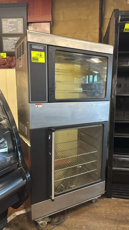 Hobart HRW101 electric rotisserie oven with bottom warmer. Stainless steel construction. Features upper HRO101 rotisserie oven with spit assembly, low