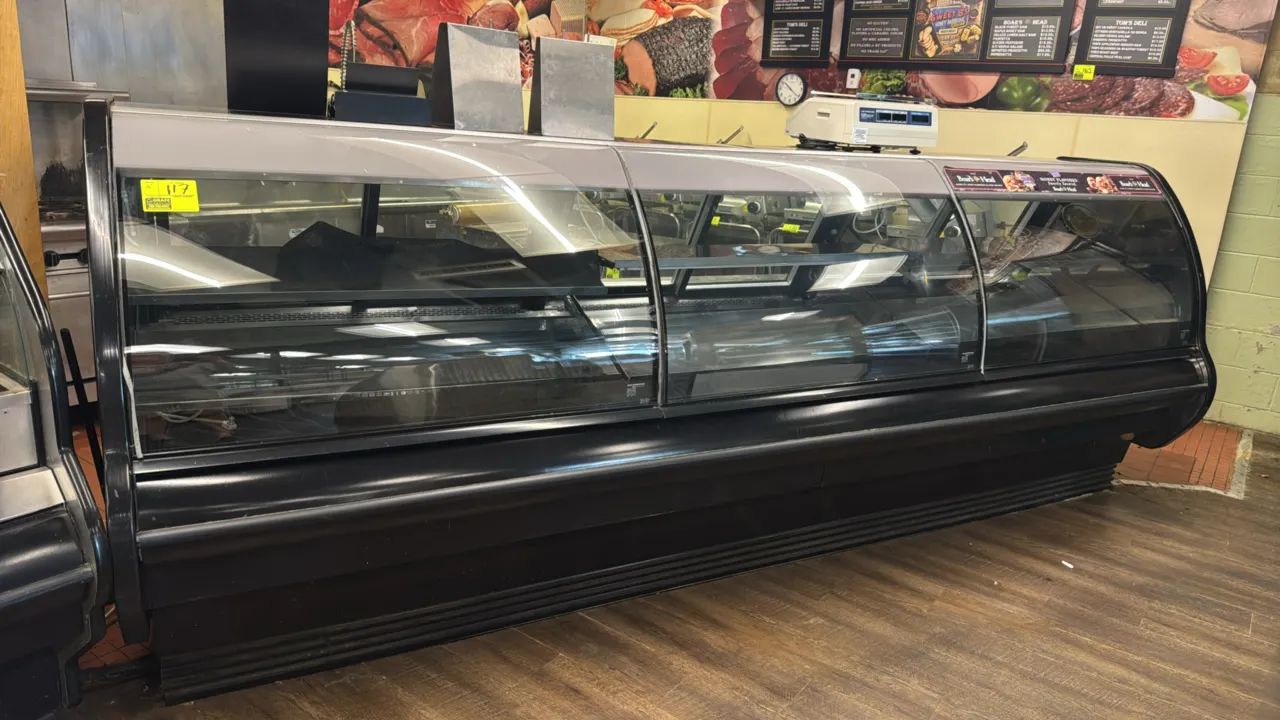Hillphoenix curved glass deli service case. Features curved front glass, rear sliding doors, stainless steel interior shelf, and stainless steel rear