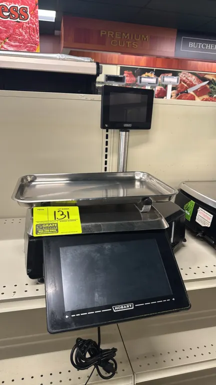 Hobart HTi-7ELH4 touchscreen electronic scale. Features integrated label printer, 9" customer display screen, and stainless steel platter. 30 lb capac