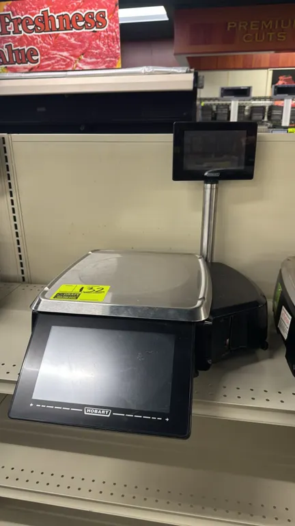 Hobart HTi touchscreen electronic scale with integrated label printer. Features stainless steel weighing platter, front operator touchscreen, and 9" e