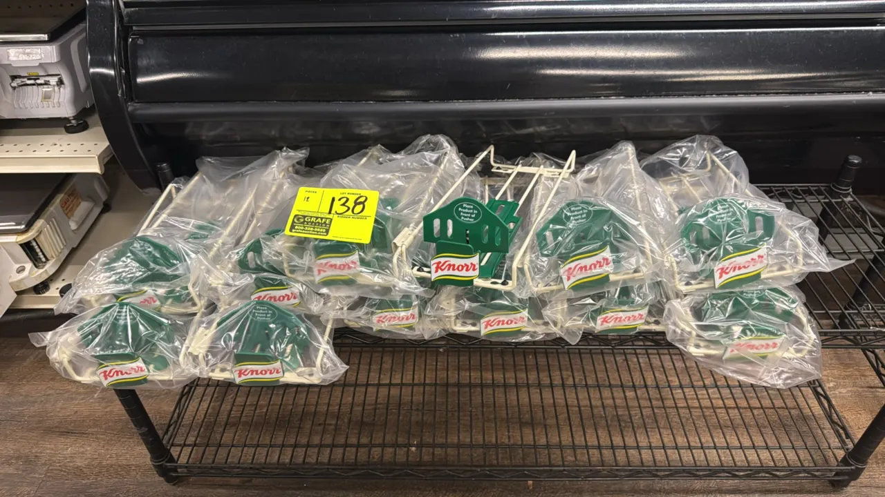 Knorr wire shelf product pusher racks. Features spring-loaded green plastic pushers with Knorr branding. Designed for retail packet merchandising. Ind