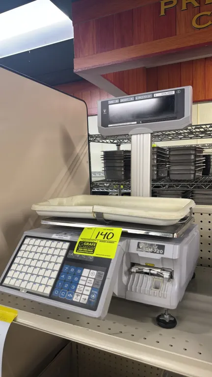 Digi SM-720 electronic scale with label printer. Features 30 lb capacity, raised customer tower display, preset PLU keypad, and removable plastic tray