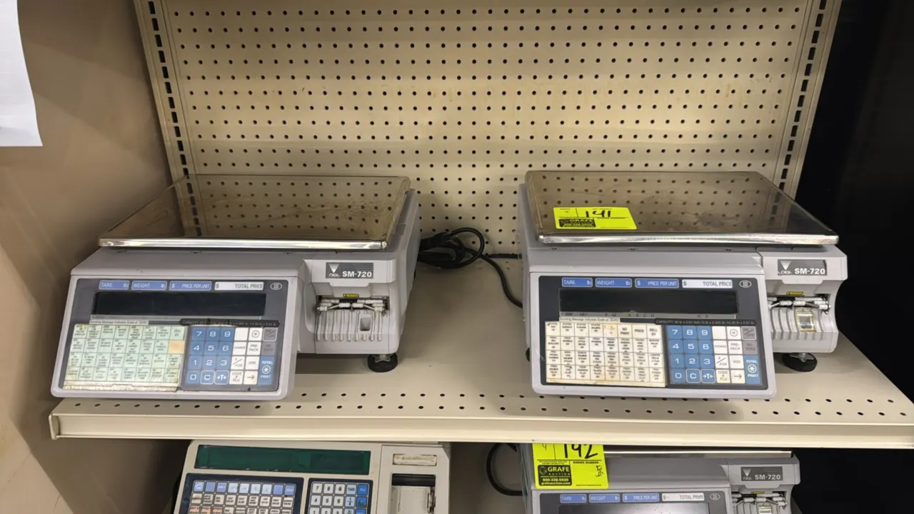 Digi SM-720 electronic computing scales. Features integrated thermal label printer, stainless steel weighing platter, digital operator display, and nu