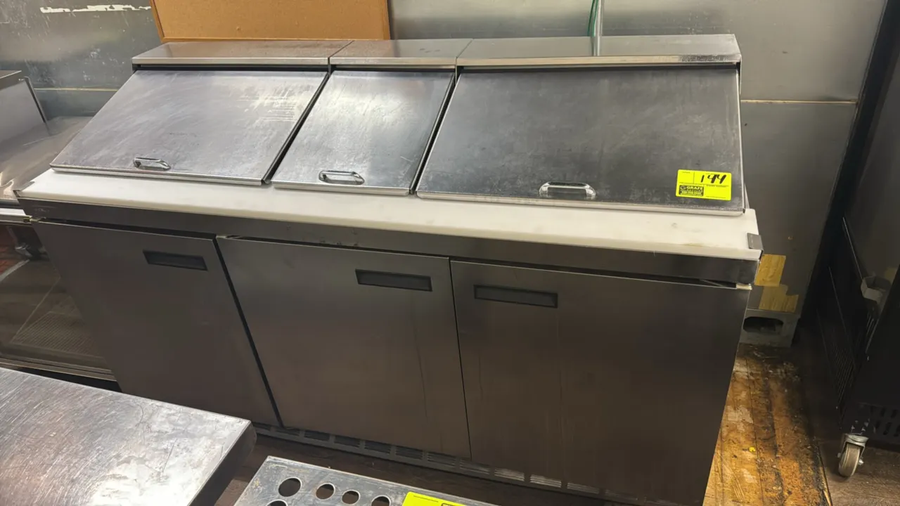 Delfield 4472N-30M stainless steel refrigerated prep table. Features self-contained refrigeration, 3 solid doors, full-length prep cutting board, and