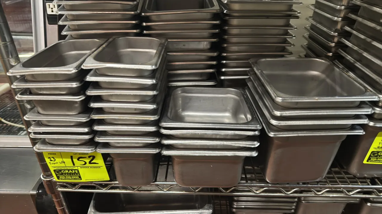 Stainless steel insert pans. Features an assortment of 1/9-size and 1/6-size pans. Depths range from 2" to 6". Shelving and surrounding items not incl