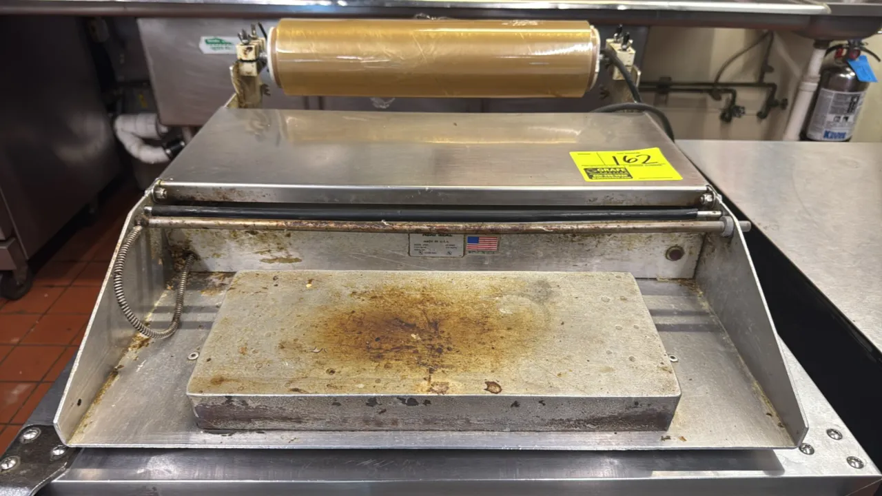 Heat Seal 625A single roll film wrapper. Features stainless steel construction, heated seal plate, cut-off rod, and single roll film cradle. S/N: 2007