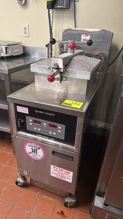 Henny Penny 500 electric pressure fryer. Stainless steel construction. Features Computron 1000 digital controls, lid lock mechanism, pressure gauge, a