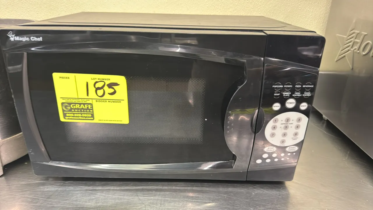 Magic Chef countertop microwave oven. Features digital touchpad controls, express cooking presets, and rotating glass turntable. Black finish. Note: R