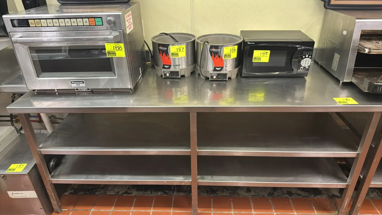 Stainless steel work table. Features a rear backsplash and (2) stainless steel undershelves. Dimensions: 84" x 30". Mounted on square stainless steel