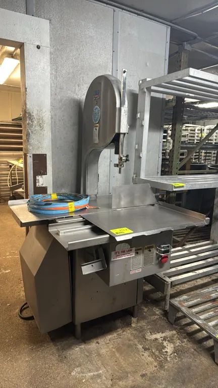 Biro 3334 stainless steel meat saw. Features a sliding meat table carriage, stationary table, adjustable thickness gauge plate, and safety shutoff swi
