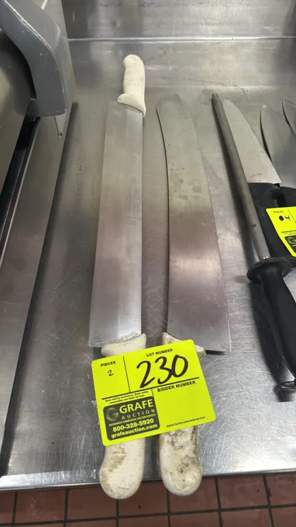 Dexter-Russell and assorted double-handled pizza rocker knives. Features stainless steel blades and dual white textured handles. Dimensions: 16" and 1
