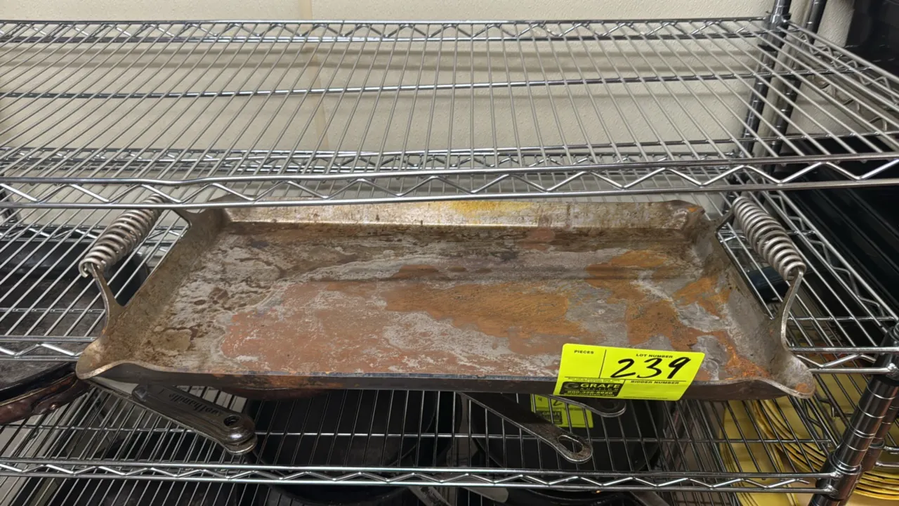 Metal broiling tray. Features dual coiled wire spring handles and raised rim. Dimensions: 23" x 12". Note: Heavy surface rust present.
