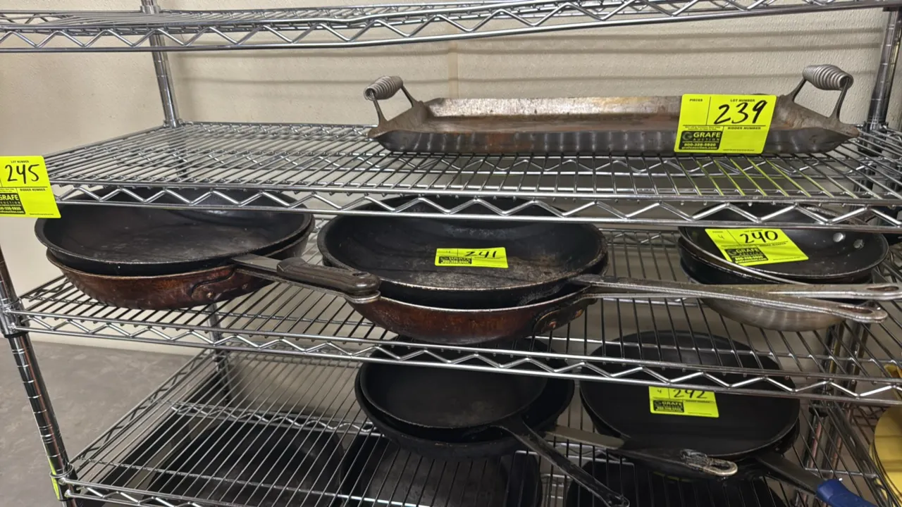 Aluminum frying pans. Features riveted metal handles and flared rims. 14"Dia. Shelving not included.